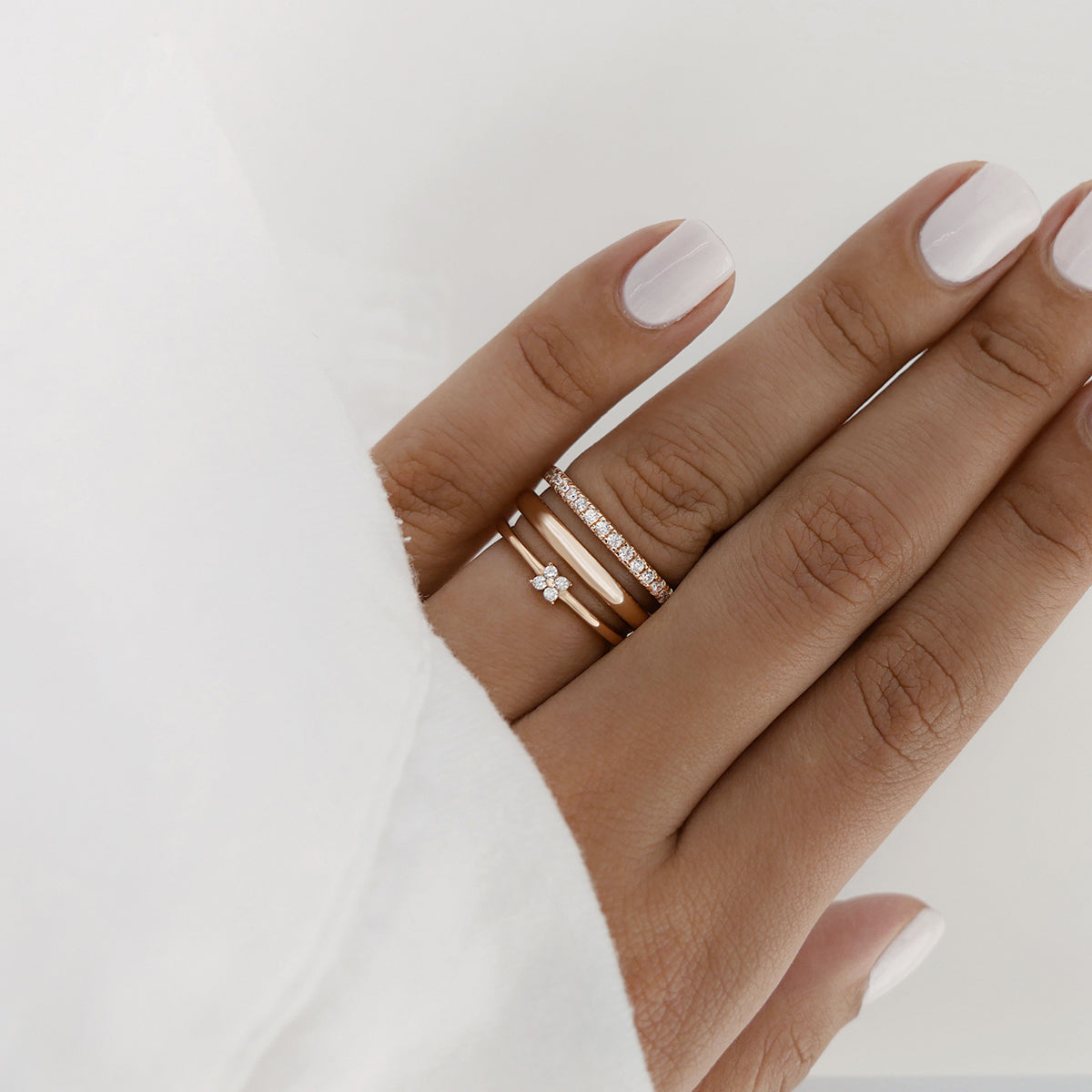 rose gold rings with white zirconia stones stacked on ring finger